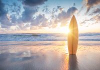 Surfboard on the beach at sunset