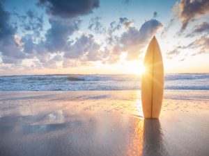 Surfboard on the beach at sunset